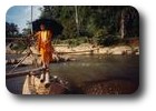 Monk crossing river at Tham Xang near Vang Vieng, Laos