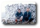 Jon and Kevin crouching on the icy summit of Scafell Pike, Lake District, England